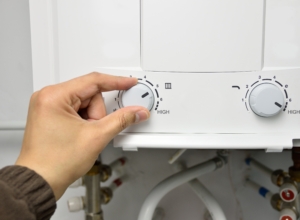 closeup of hand adjusting water heater